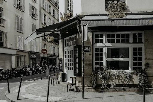 Black motorcycle parked beside brown concrete building